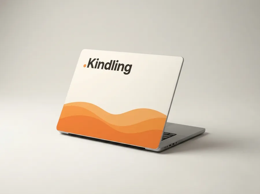 Laptop with an off-white cover, an orange wave along the bottom and the word Kindling