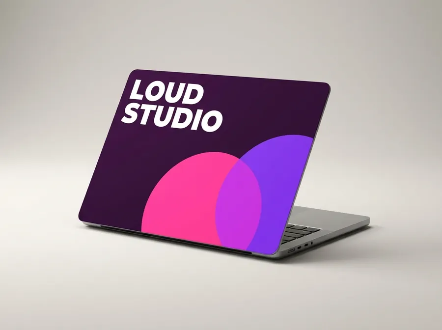 Laptop with an aubergine cover, overlapping pink and violet circles and the words Loud Studio