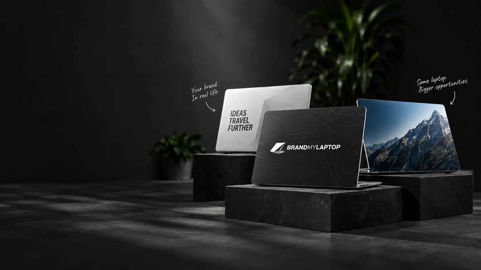 Three laptops on dark stone plinths, each with a different branded cover